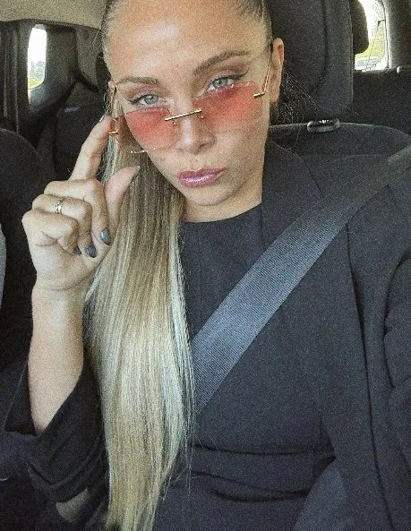 Selfie de Ailu Greco con anteojos rosas mostrando sus uñas