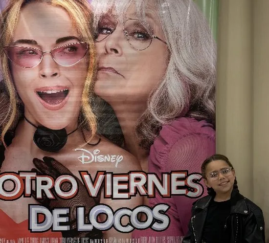 Juana en el cine junto al afiche de Otro viernes de locos