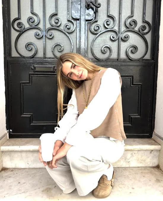 Julieta Carloni sentada frente a una puerta de hierro
