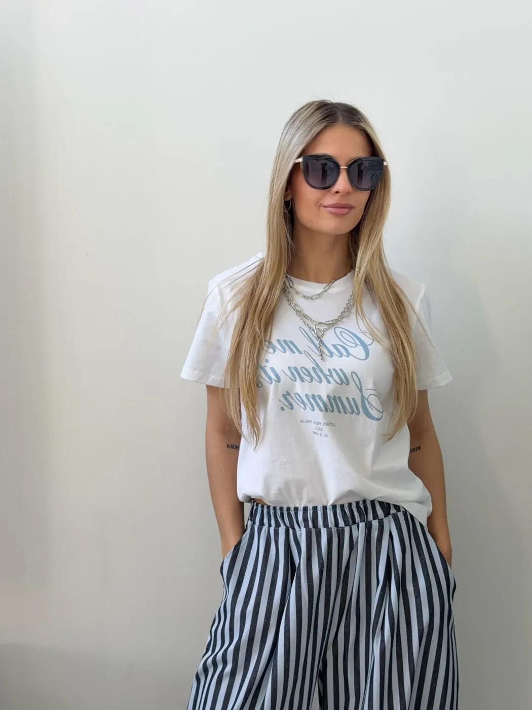 Remera blanca y pantalón rayado de Emilia
