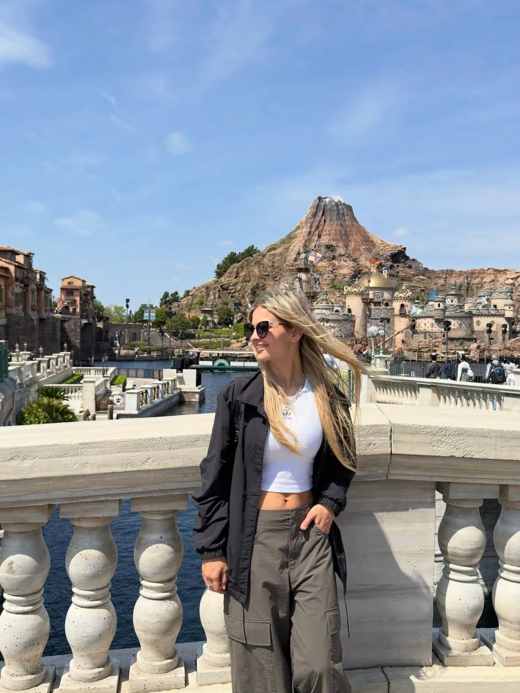 Emi en DisneySea, con el volcán de fondo