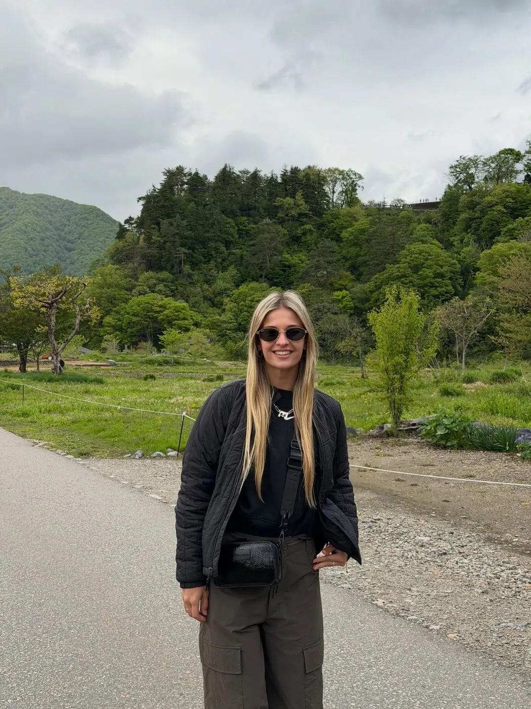 Emi parada en un camino rodeado de verde