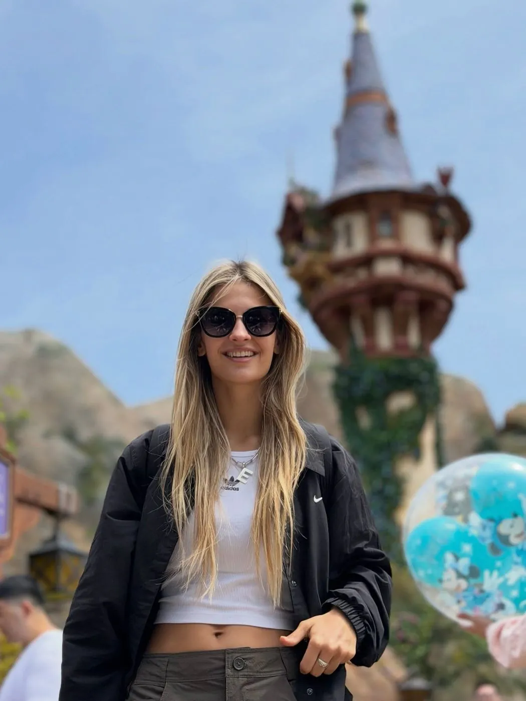Emi en DisneySea, Tokio, con la torre de Rapunzel de fondo