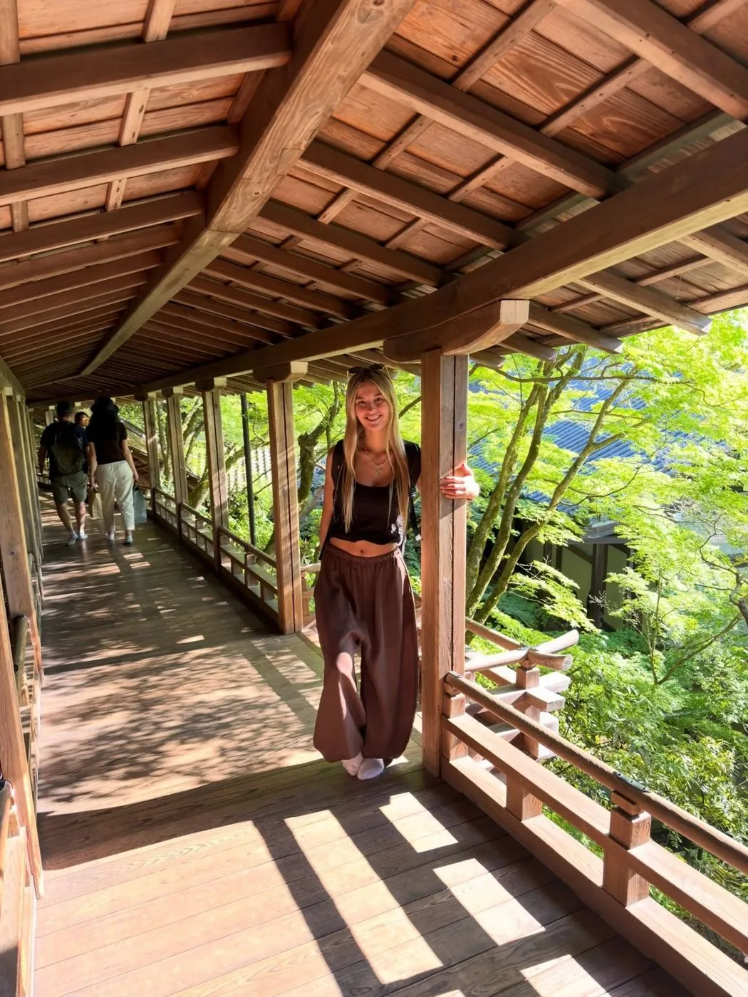 Emi en un pasillo de madera con vista al bosque