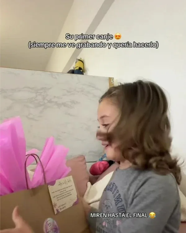 Alma abriendo una bolsa de regalo con papel rosa: su primer canje