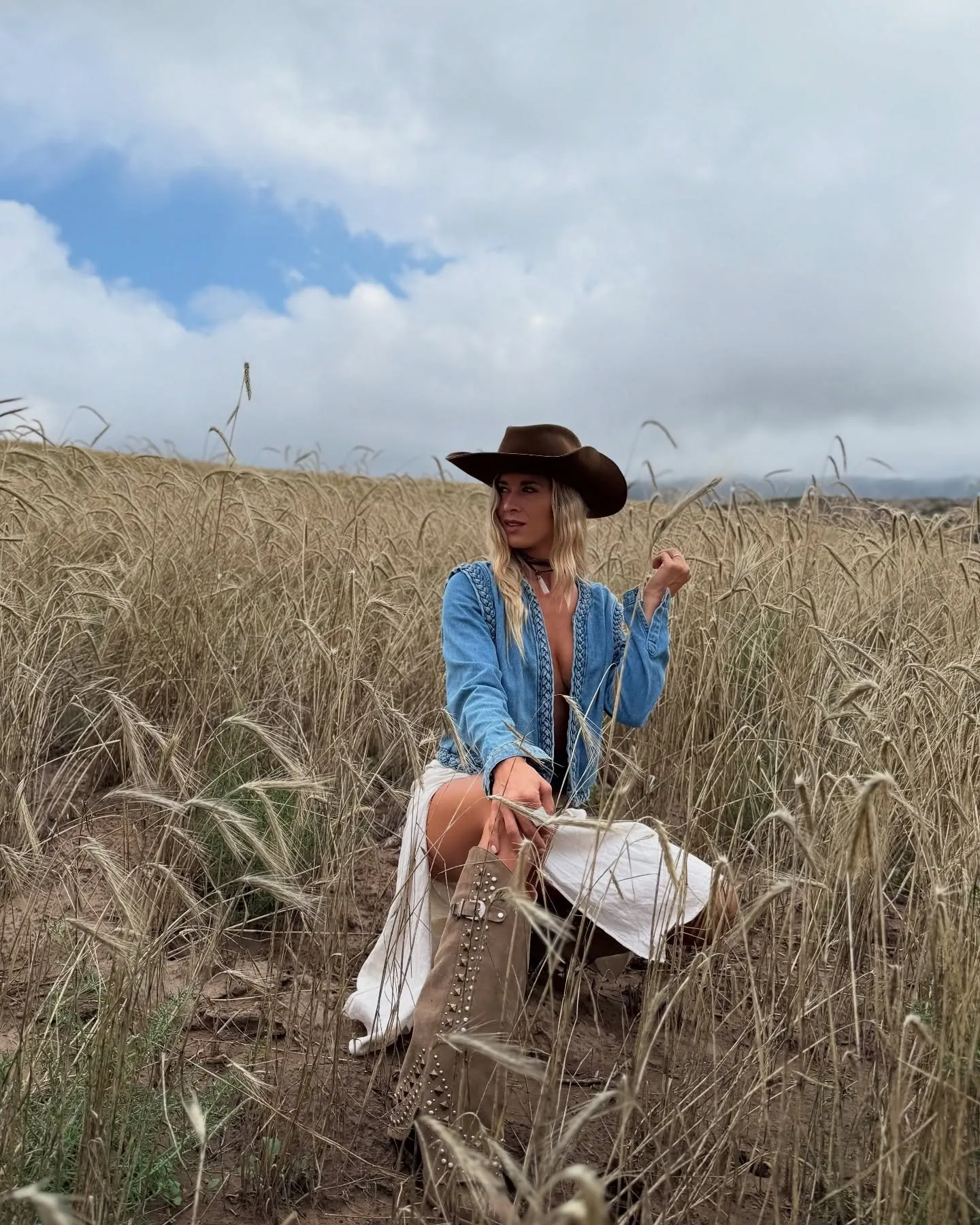 Mery Palma con sombrero vaquero parada en un campo de trigo dorado